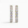 One pair of 18 karat yellow gold shared claw set diamond hoop earrings.