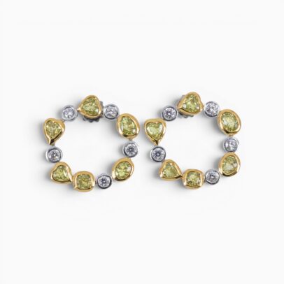 One pair of 18 karat yellow and white gold organic circle rub set diamond earrings.