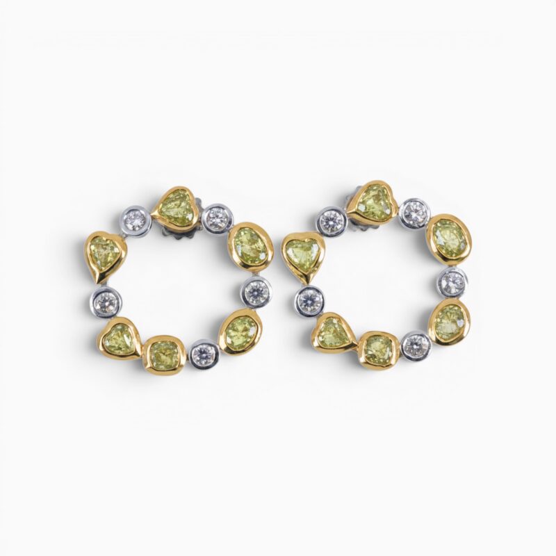 One pair of 18 karat yellow and white gold organic circle rub set diamond earrings.