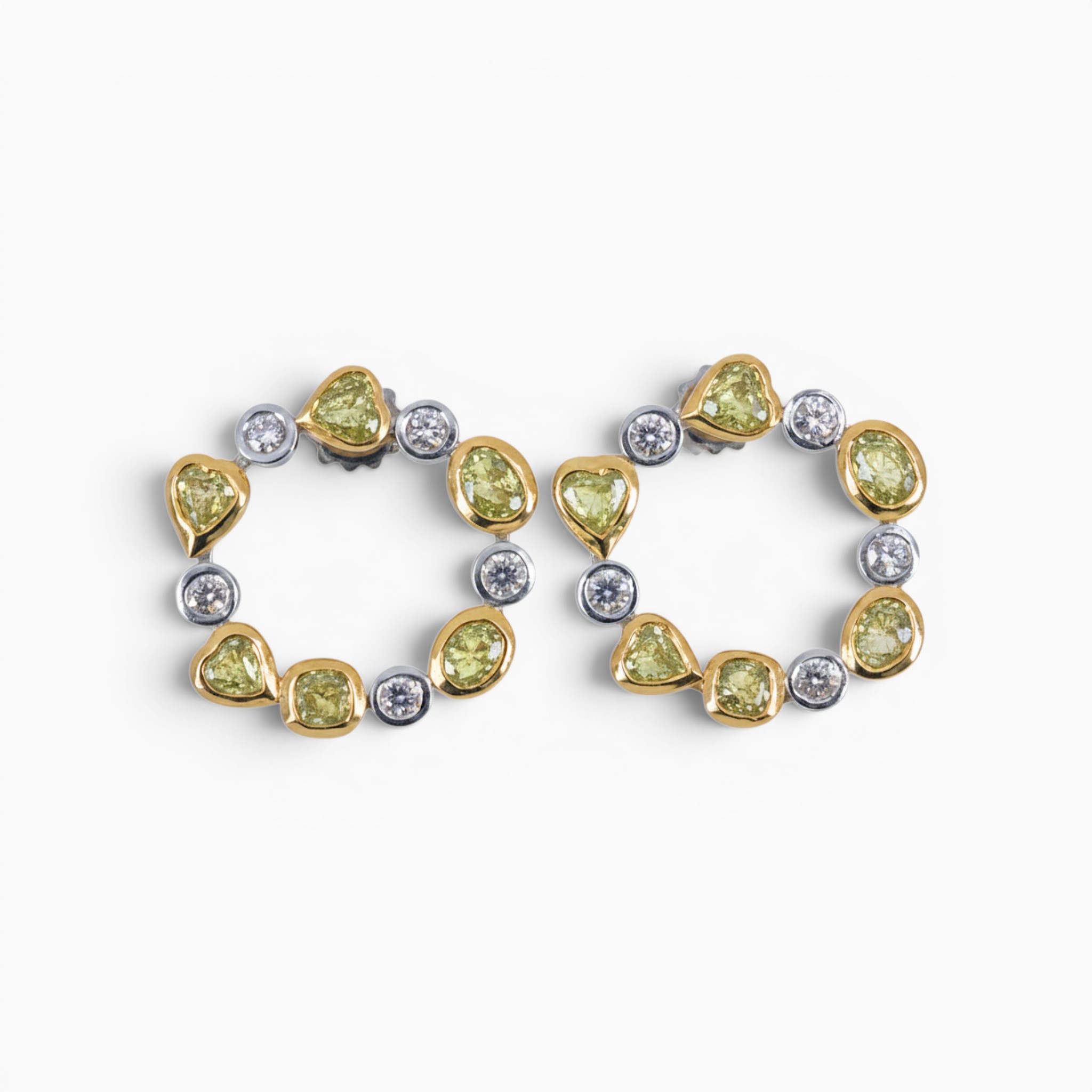 One pair of 18 karat yellow and white gold organic circle rub set diamond earrings.