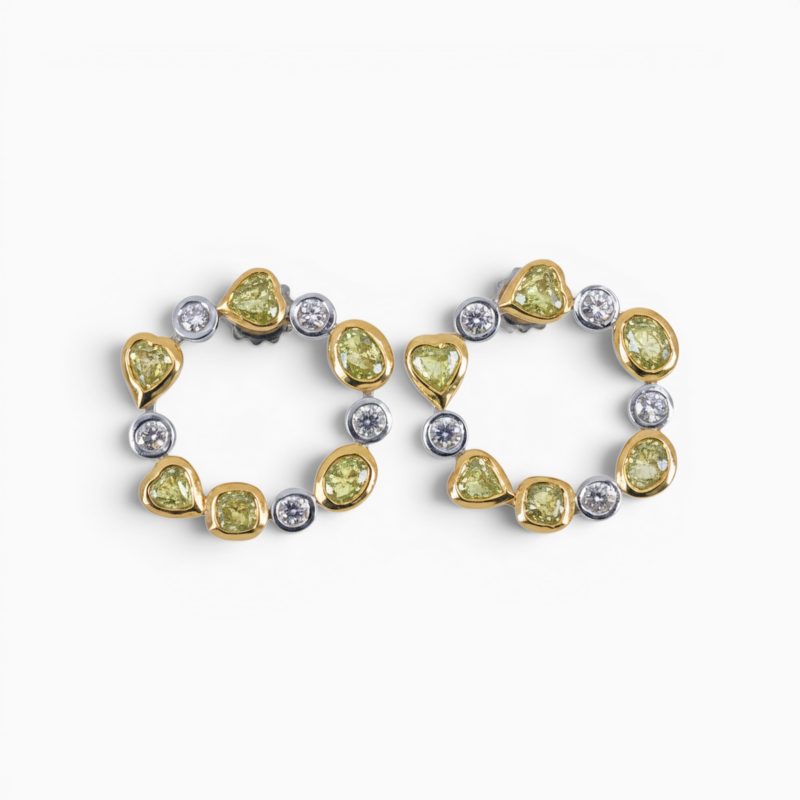 One pair of 18 karat yellow and white gold organic circle rub set diamond earrings.
